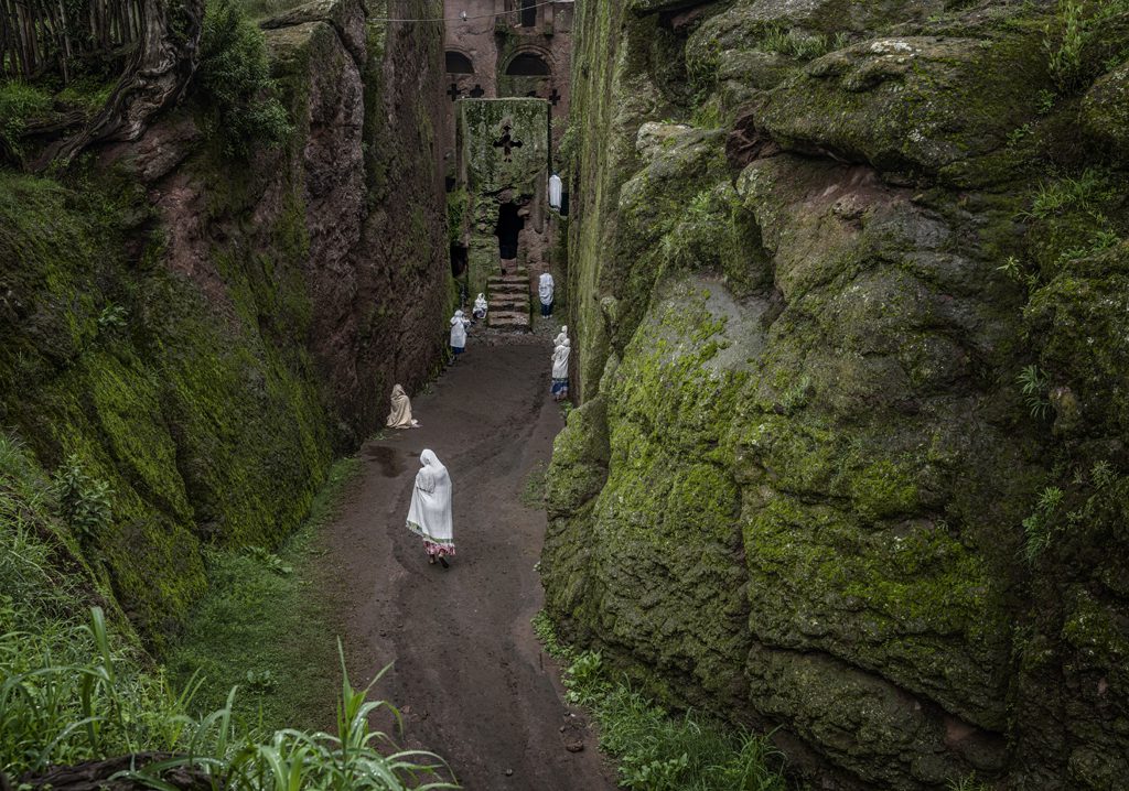 The Ethiopia Highlands are renown for their unique, ancient form of Christianity and magnificent churches carved into the volcanic rock like the entrance of the Tomb of Adam in Lalibela, where workshipers enter a corridor sliced into the mountain itself for an open-air Sunday worship service. Ethiopian Highlands.