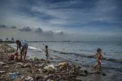 A day at the beach in Baseco slum at the mouth of the Pasig River, where these waters contain human waste, including antibiotic resistant bacteria, even heavy metals into Manila Bay. It is hard to imagine a less healthy place to swim. Baseco slum, Manila, Philippines.